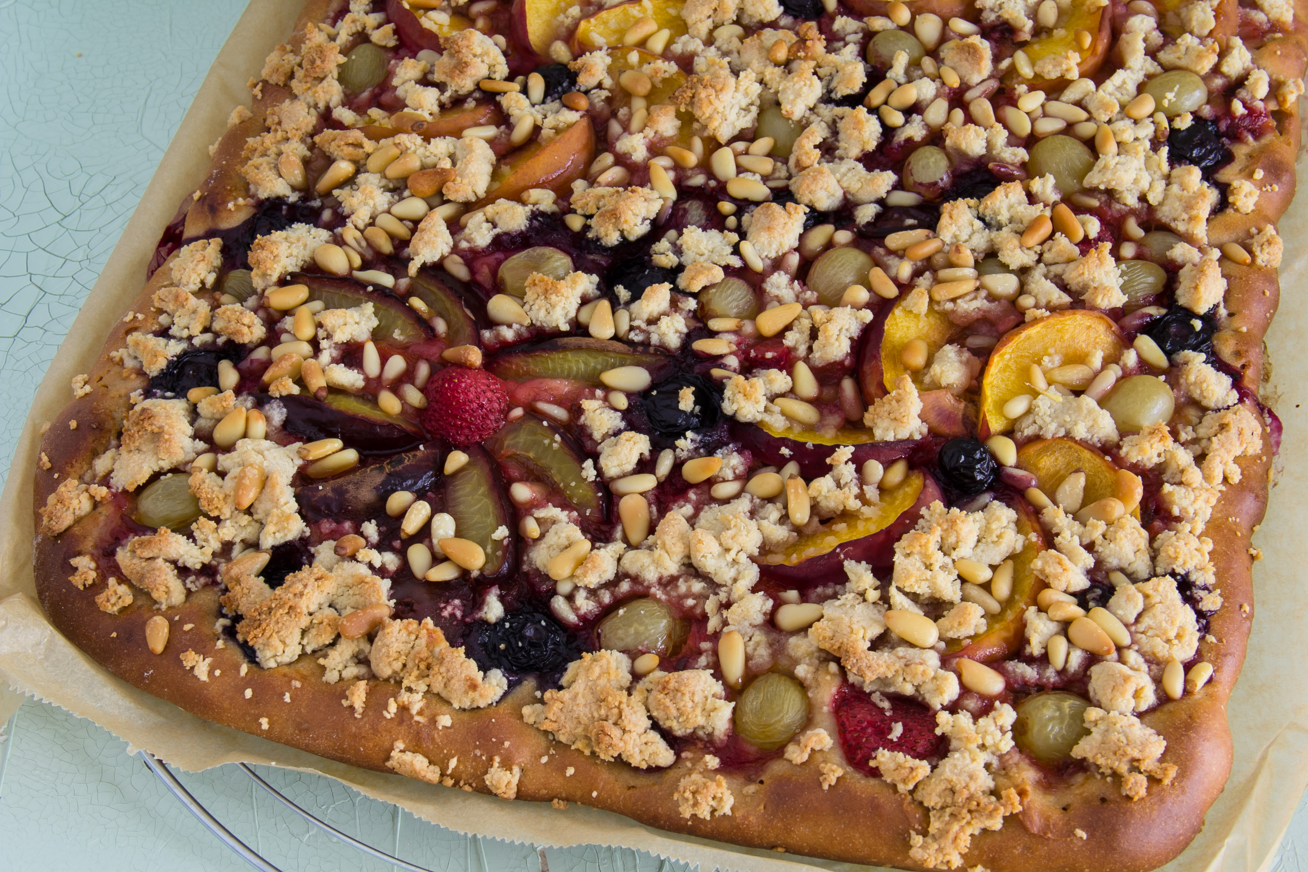 Mediterraner Hefekuchen mit saisonalem Obst, Mandelstreuseln & Pinienkernen