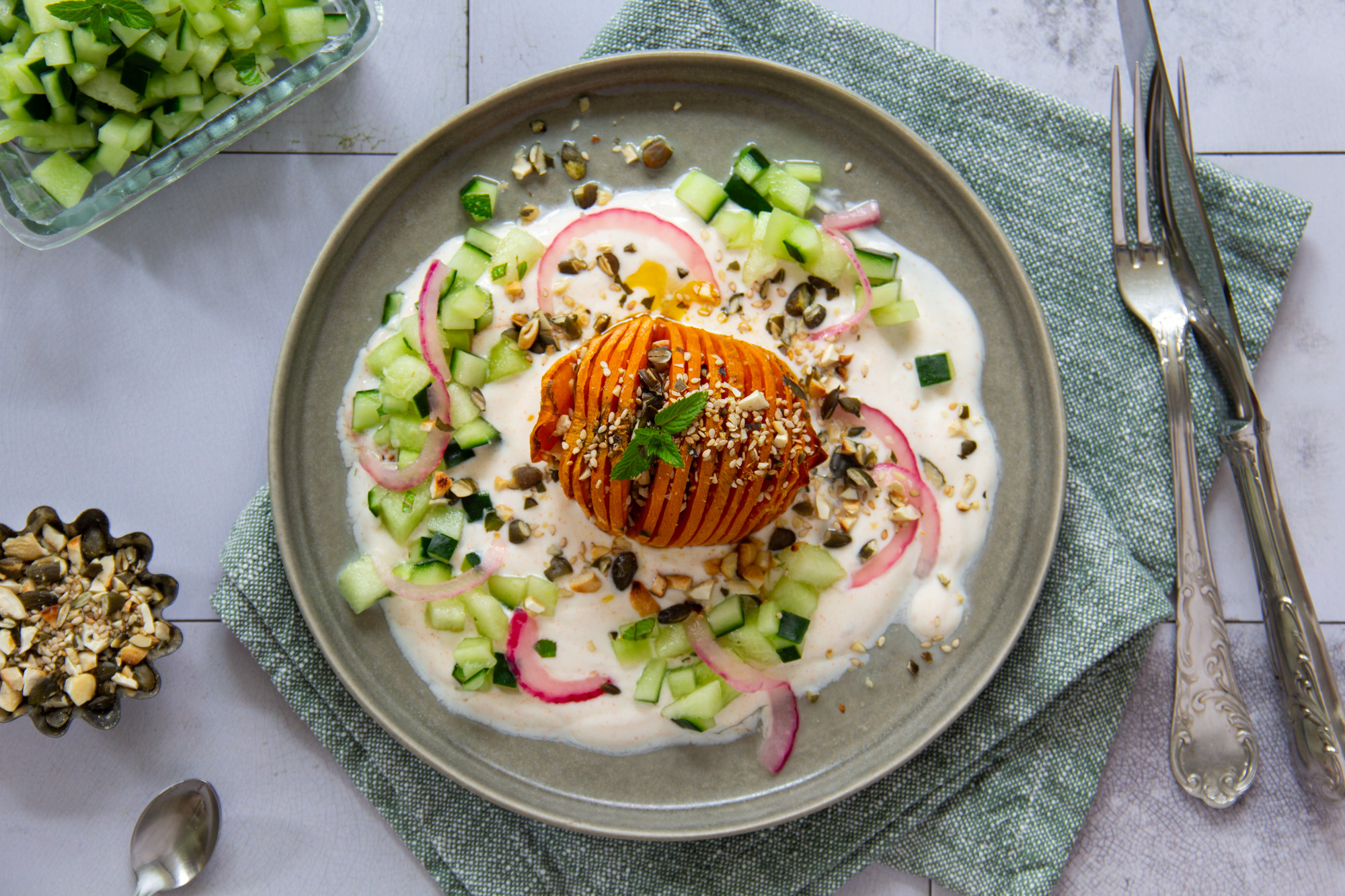 Hasselback Sweet Potatoe mit Joghurt, minzigem Gurken-Melonen-Salat & kernigem Crunch